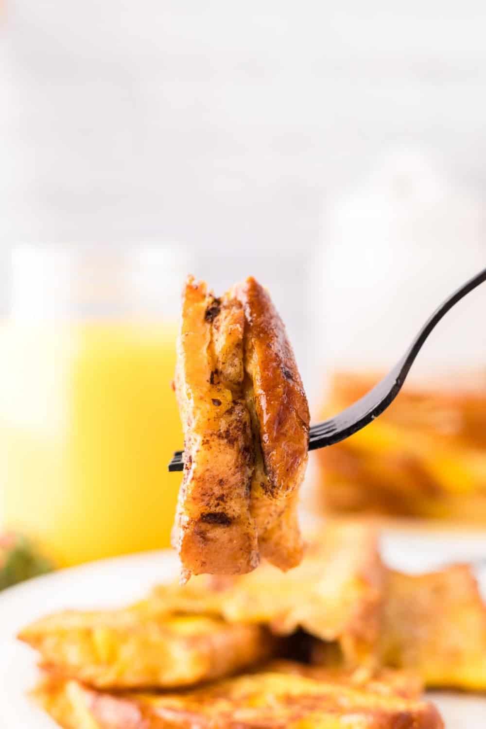 a forkful of challah french toast ready to be eaten.