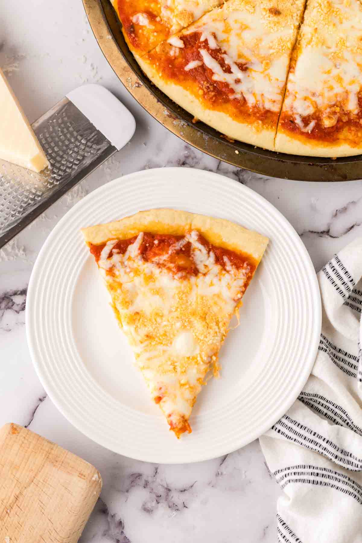 one slice of cheese pizza on a white plate.