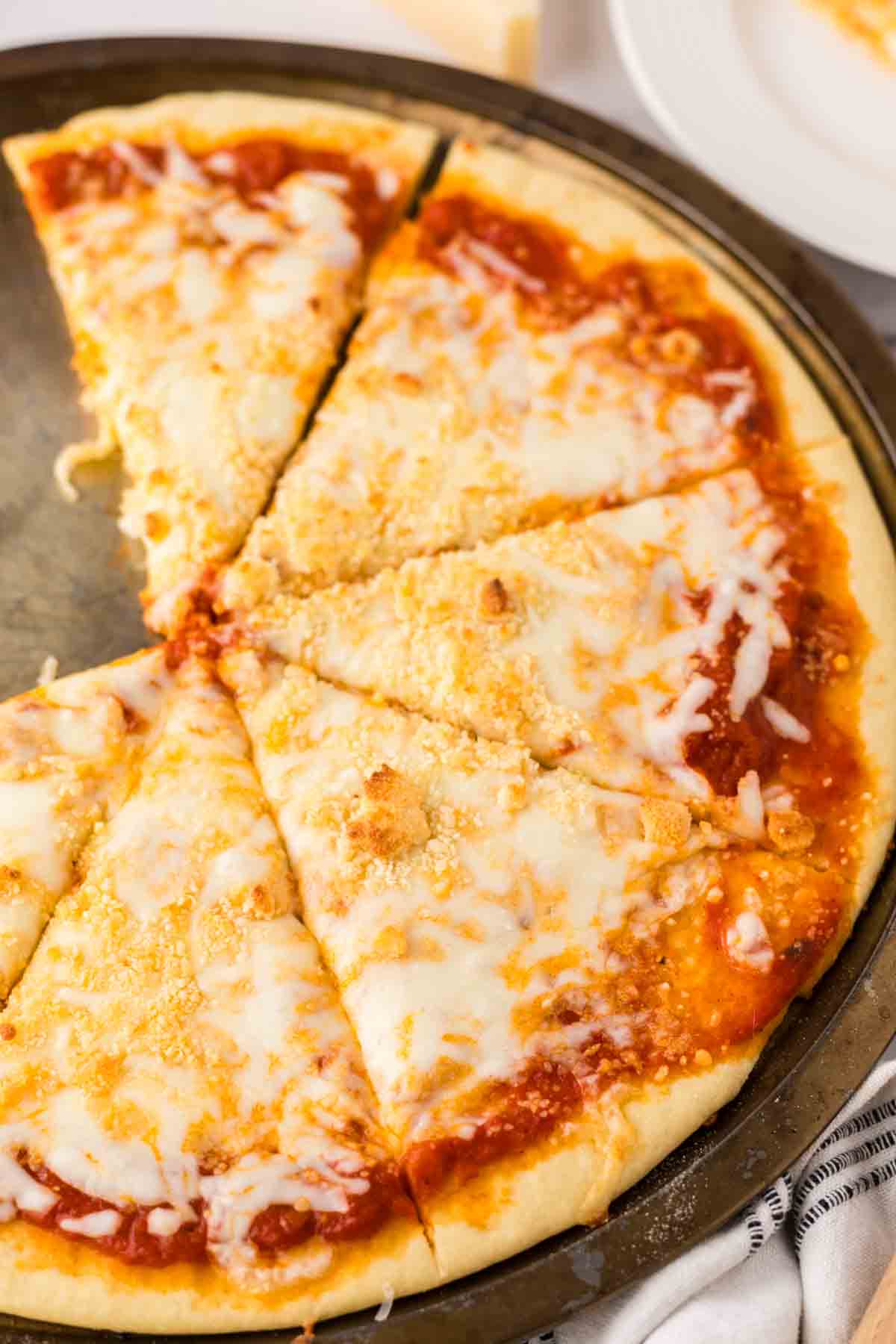 baked cheese pizza recipe on a tray.