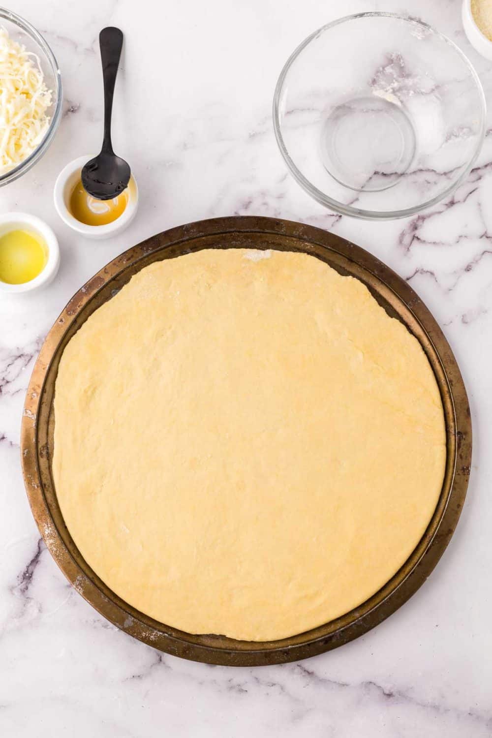 round pizza tray with raw dough on top.