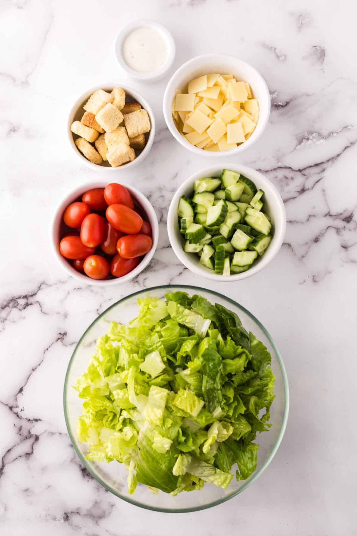 portion bowls each with raw ingredients to make chef's salad recipe.