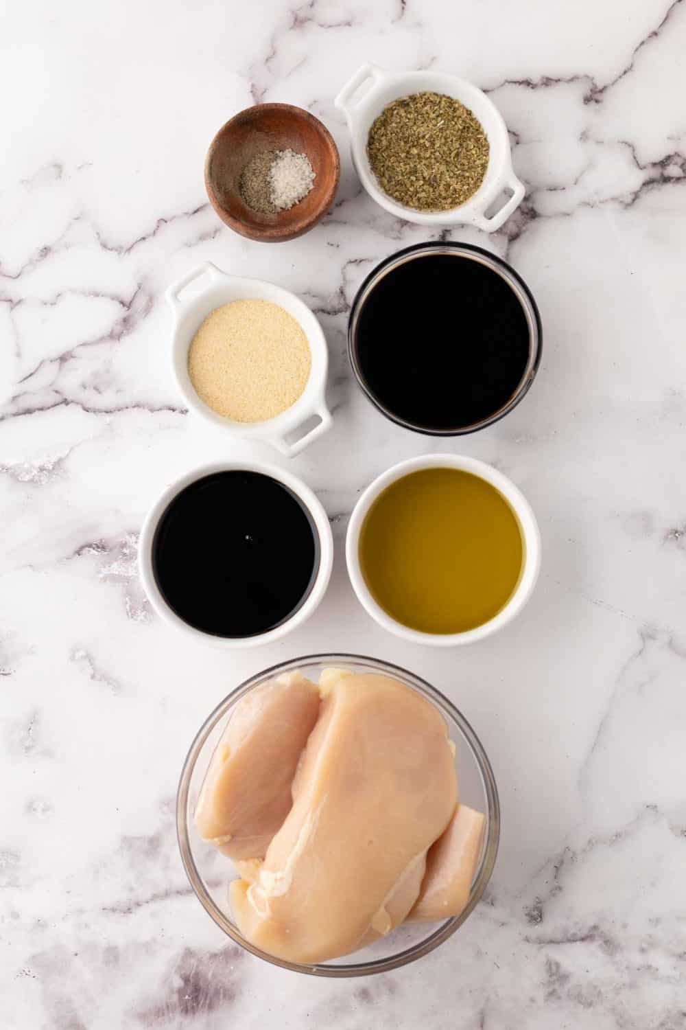 portion bowls each with raw ingredient to make chicken marinade.