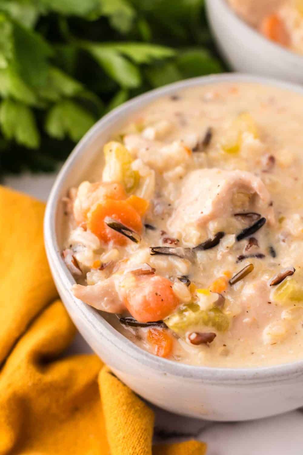 white bowl with chicken wild rice recipe and a black spoon.
