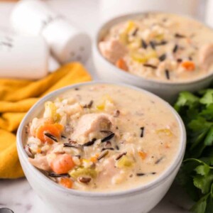 white bowl with chicken wild rice recipe and a black spoon.