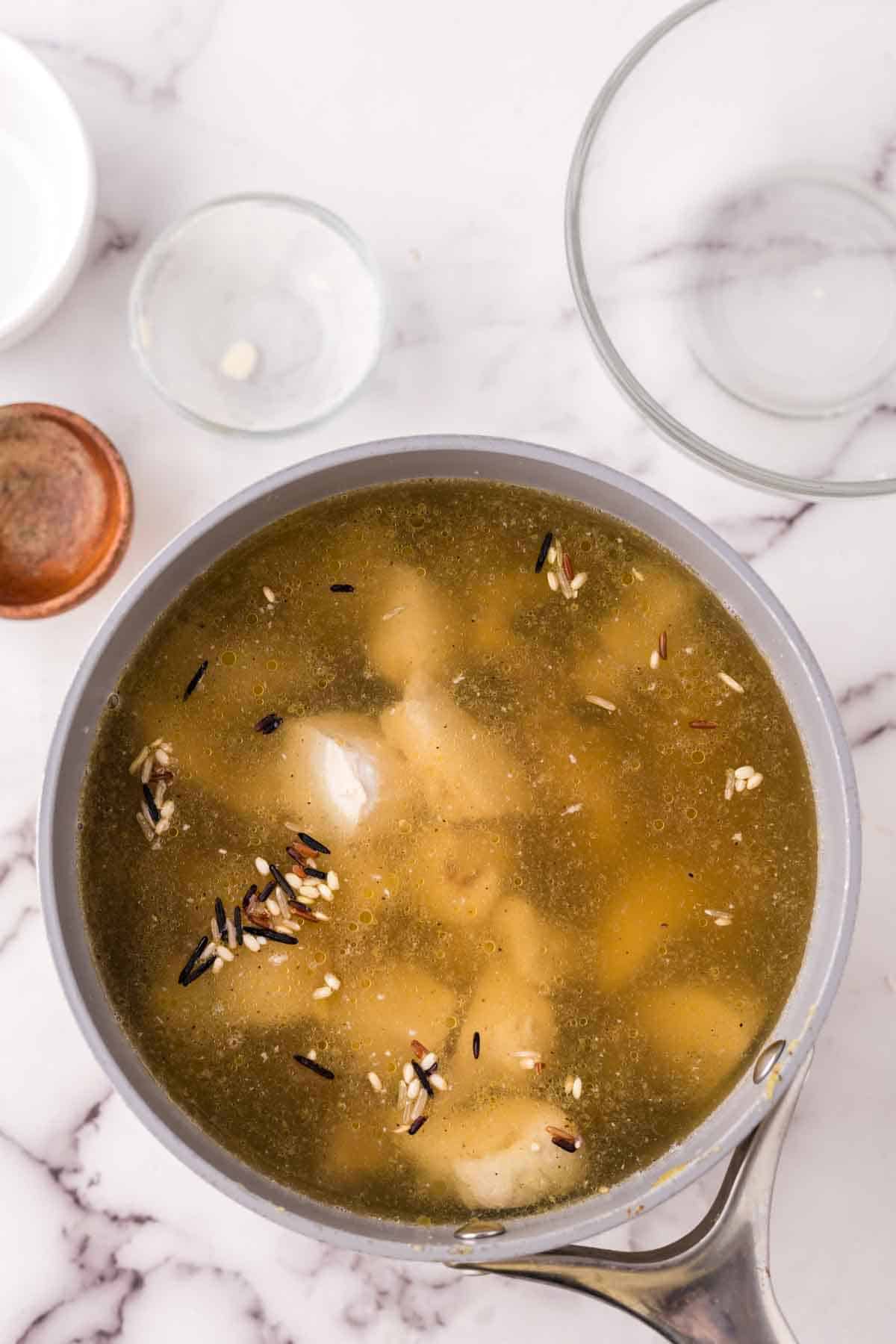 large cooking pot of chicken wild rice soup in progress.