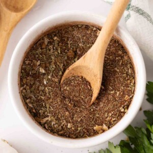 small white bowl with chili seasoning and a cute wooden spoon.