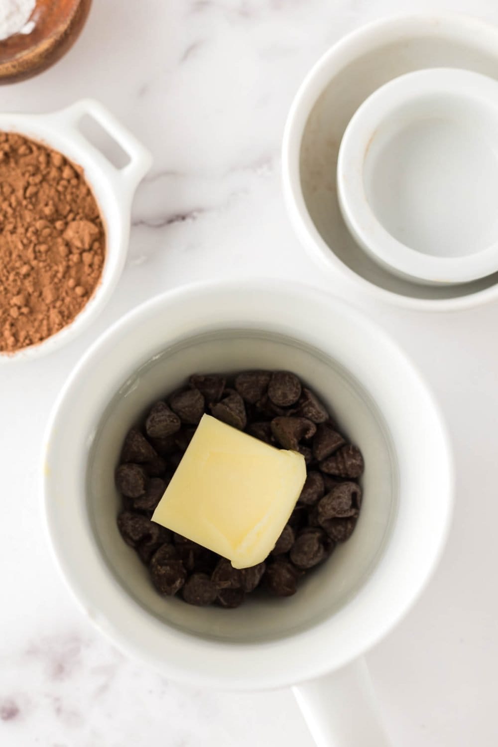 Chocolate cake batter in progress in a white coffee mug.