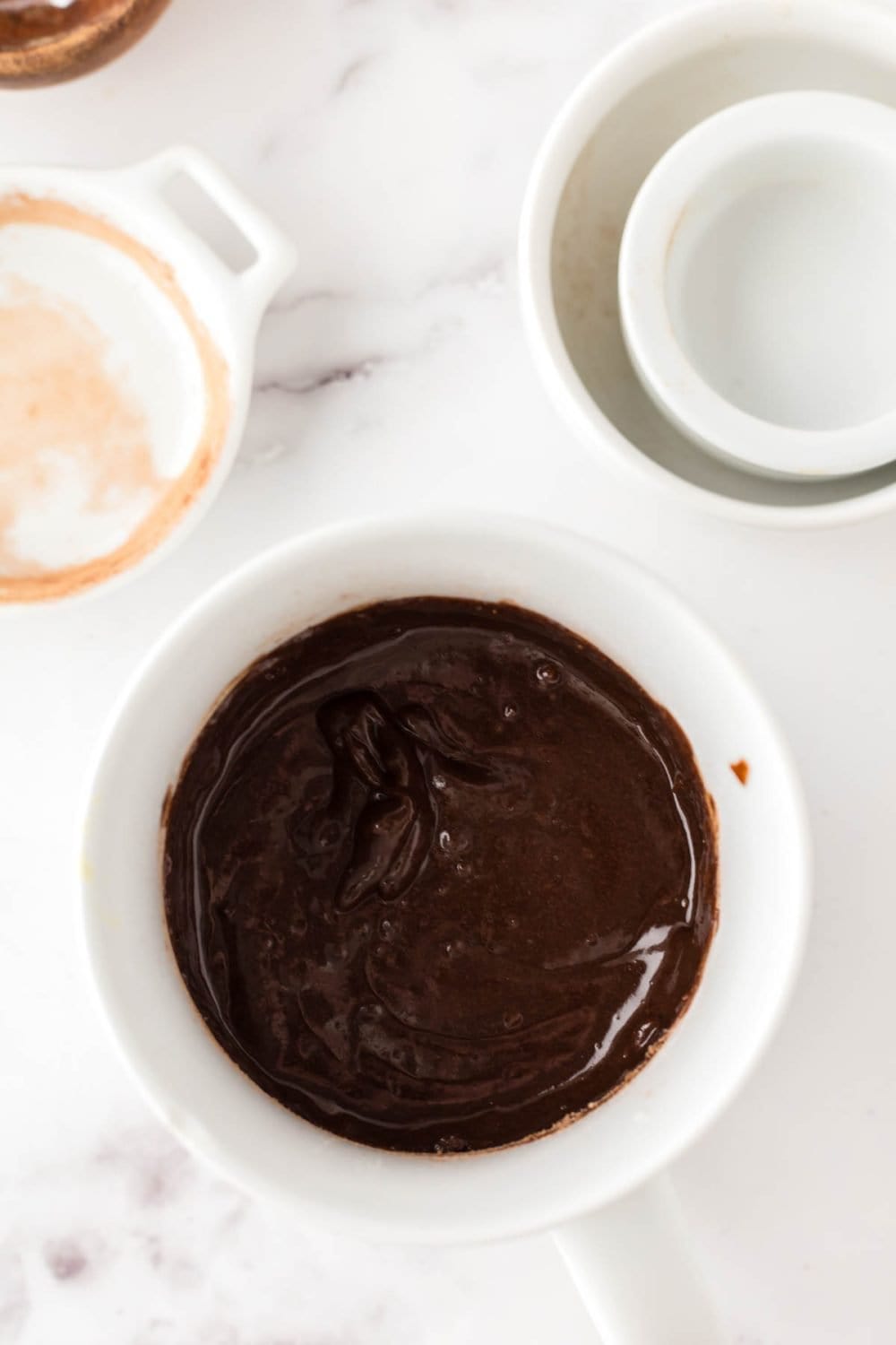 raw chocolate cake batter in a white coffee mug.