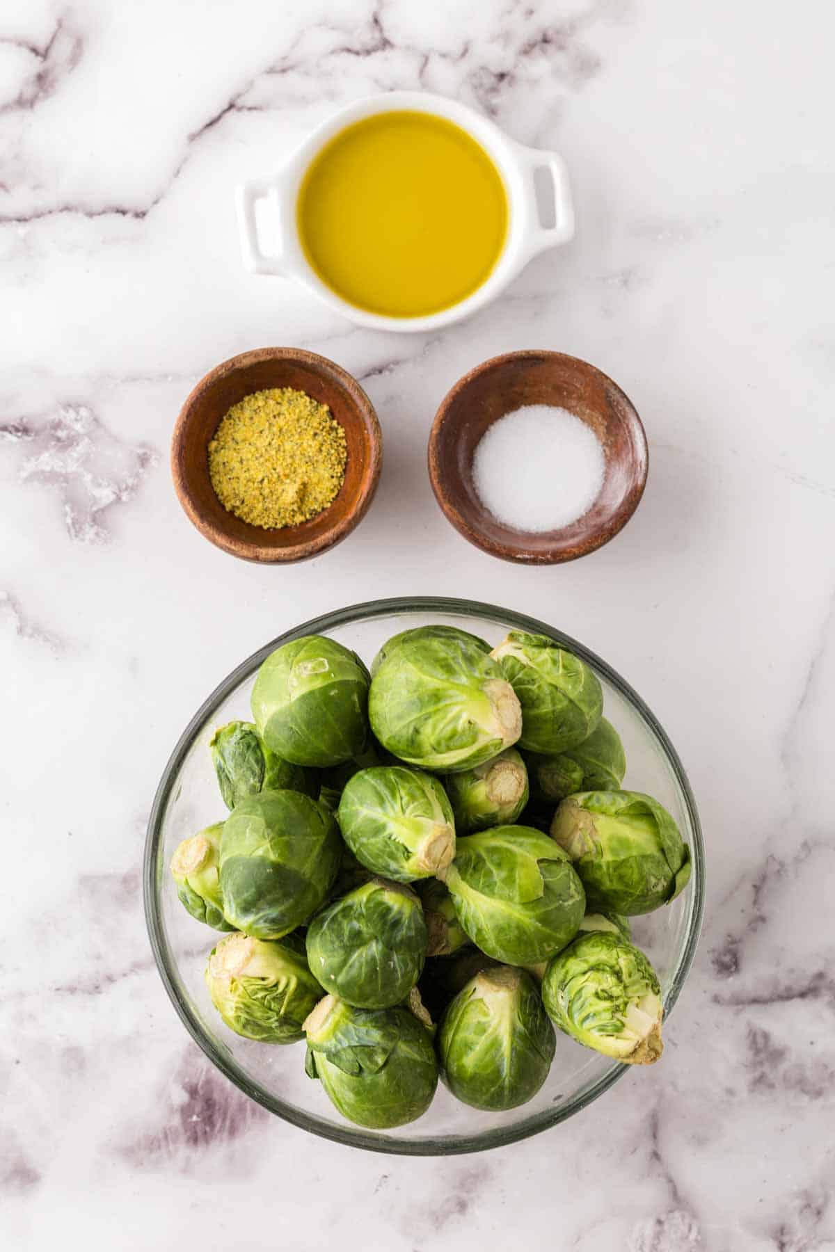 portion bowls each raw ingredient to make oven baked brussels sprouts.