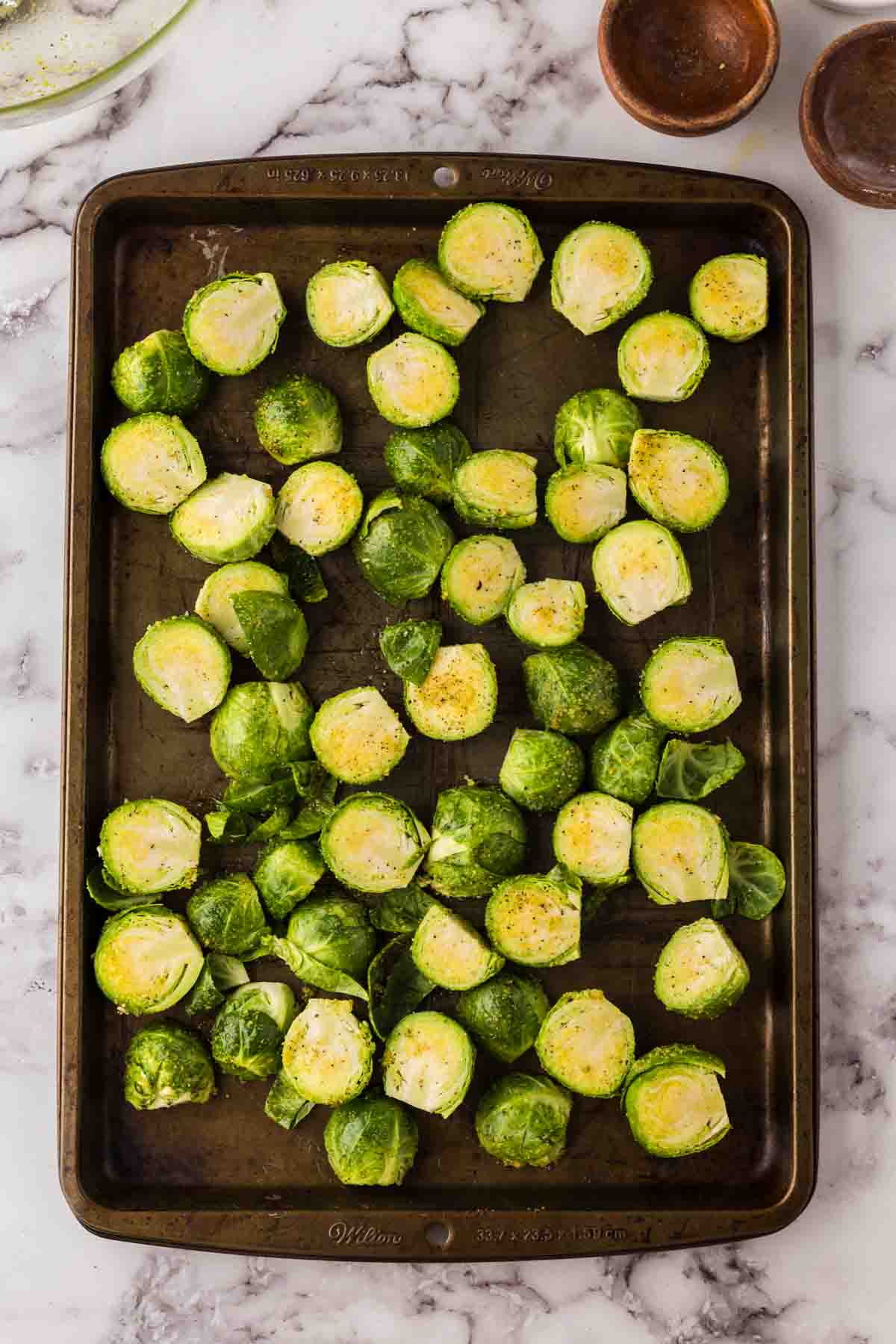 Raw Brussels Sprouts on on a baking sheet.
