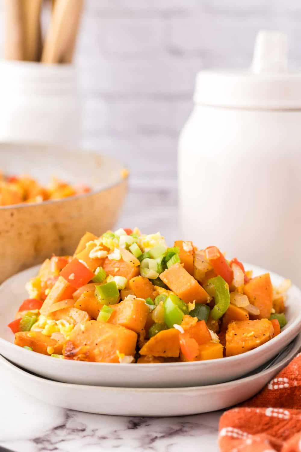 colorful sweet potato hash served on a white plate.