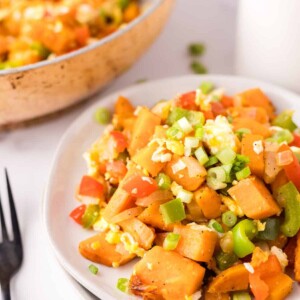 colorful sweet potato hash served on two white plates.