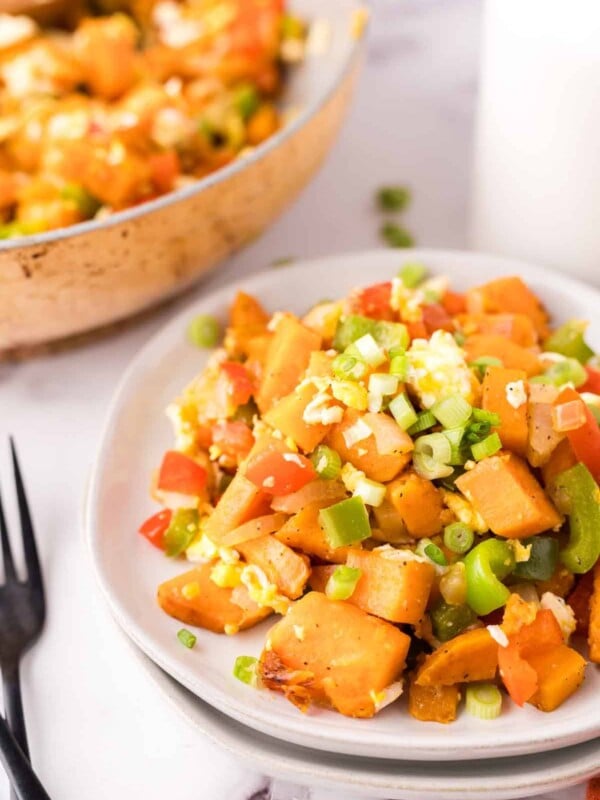 colorful sweet potato hash served on two white plates.