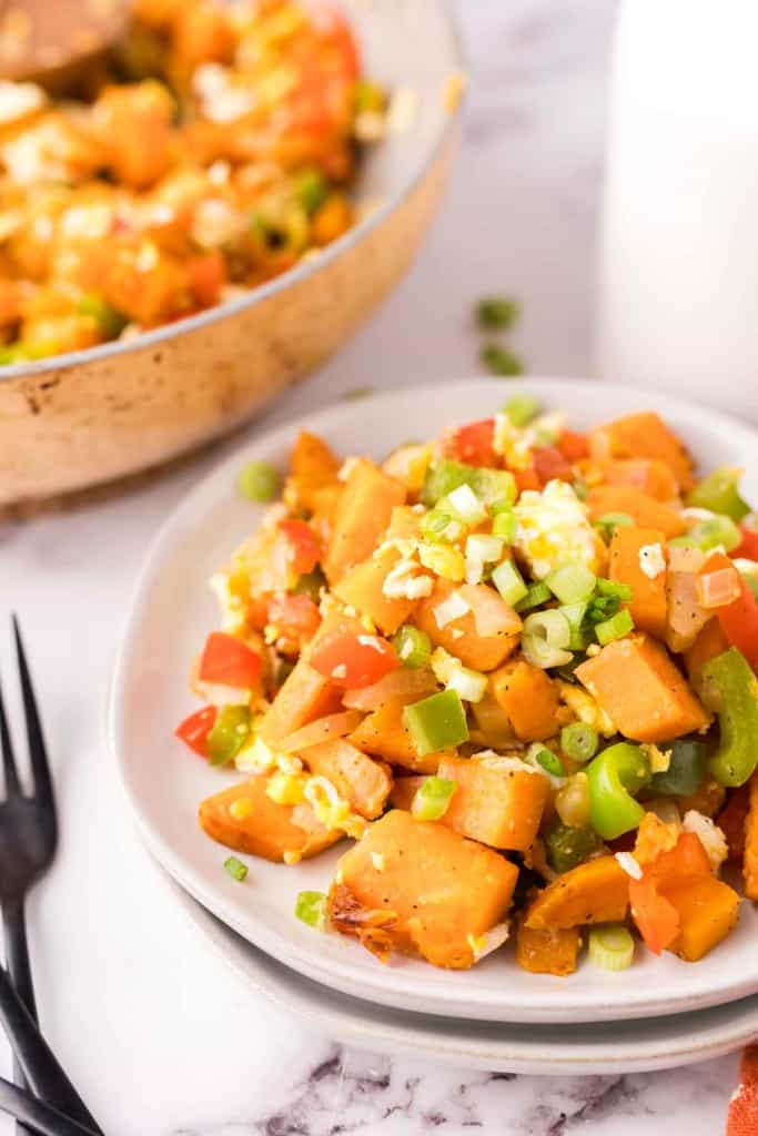 colorful sweet potato hash served on two white plates.