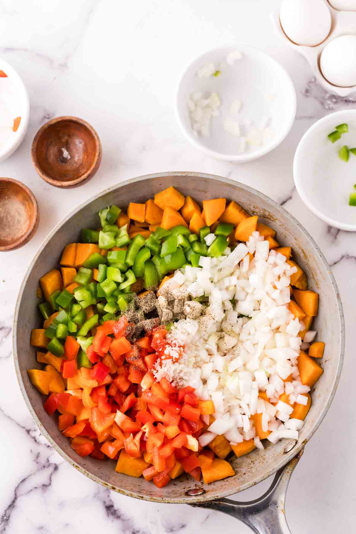 pan of raw vegetables for sweet potato hash before cooking.