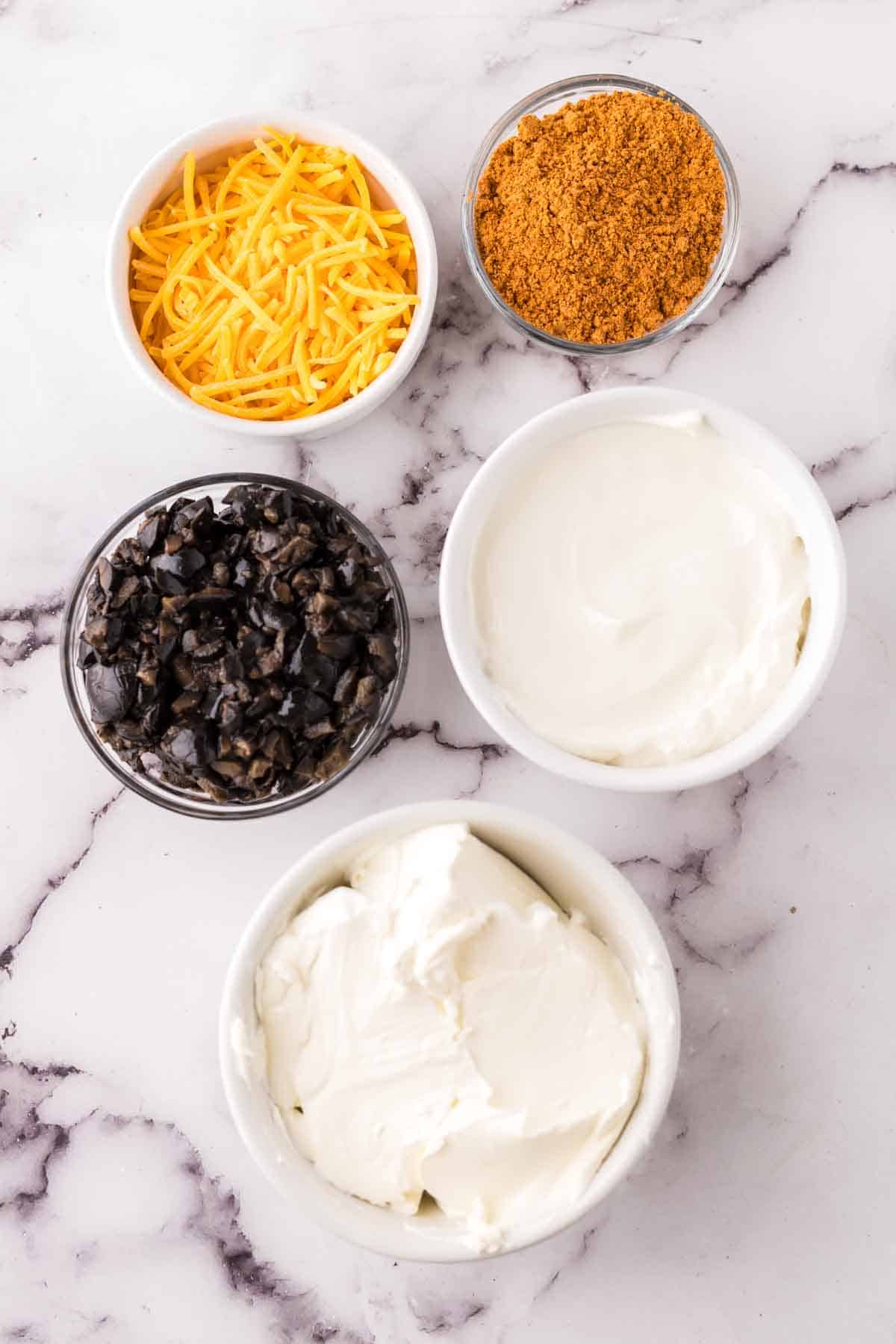 portion bowls with each raw ingredient to make taco dip.