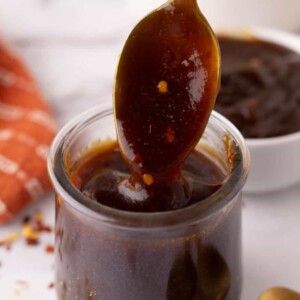 teriyaki sauce recipe in a glass jar with a golden spoon.