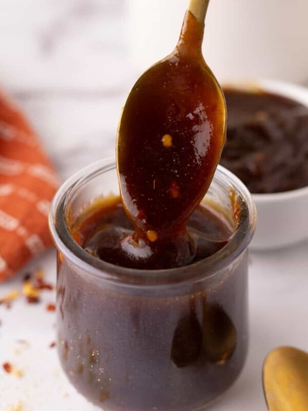 teriyaki sauce recipe in a glass jar with a golden spoon.