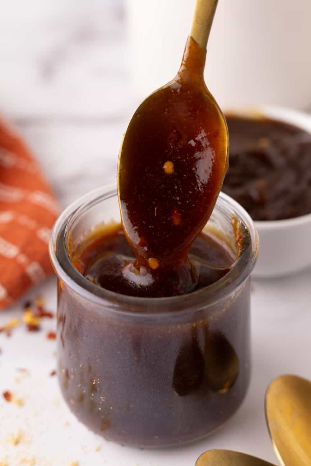 teriyaki sauce recipe in a glass jar with a golden spoon.