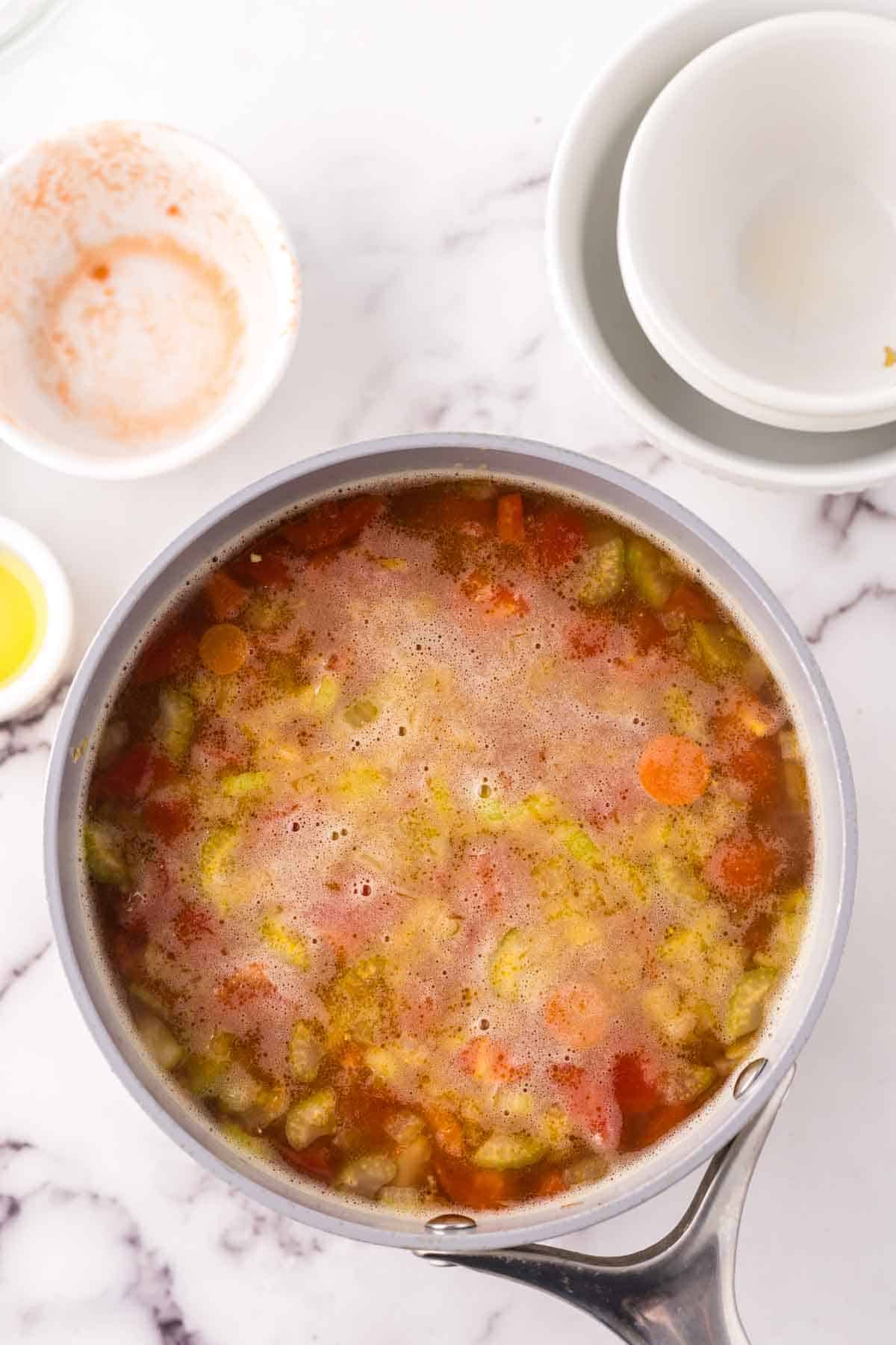 Pot of simmering vegetable soup. 