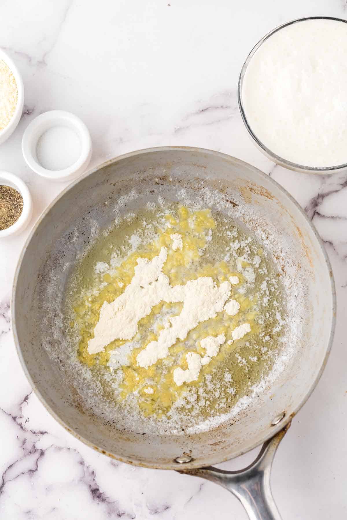 sauce pan with ingredients in progress to make white pizza sauce recipe.