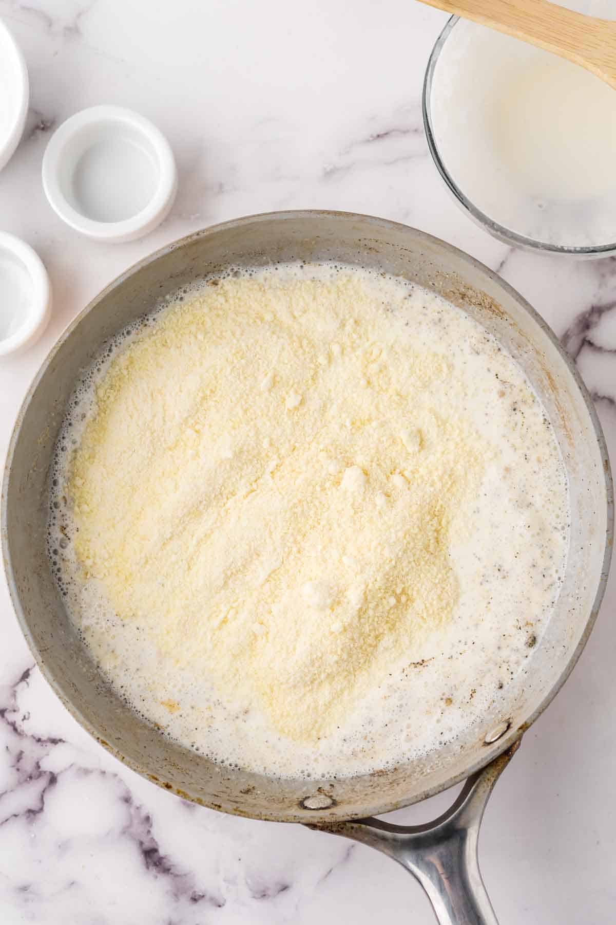 sauce pan with ingredients in progress to make white pizza sauce recipe.