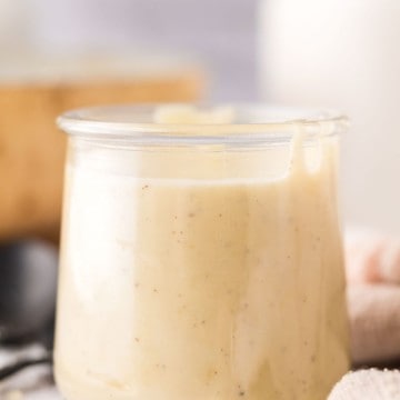 small glass jar with white pizza sauce.