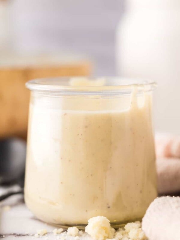 small glass jar with white pizza sauce.