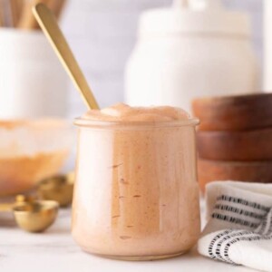 Yum Yum Sauce in a small glass jar with a golden spoon in it.