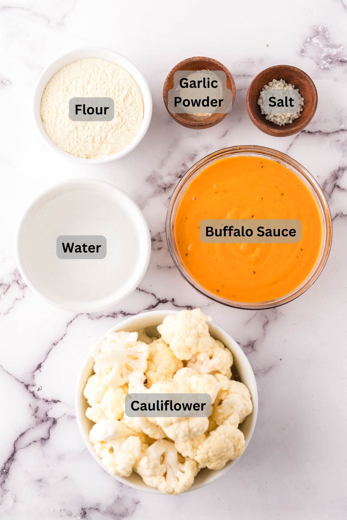 portion bowls each with digitally labeled raw ingredients to make cauliflower wings.