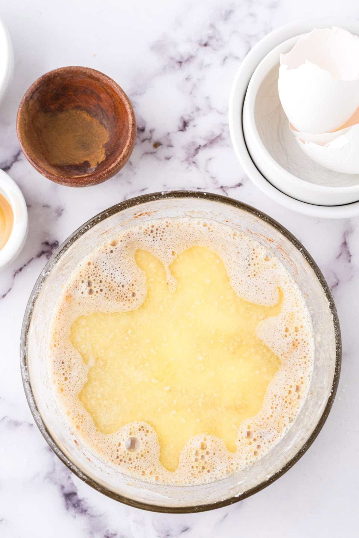 Combining eggs and other ingredients in a glass bowl .