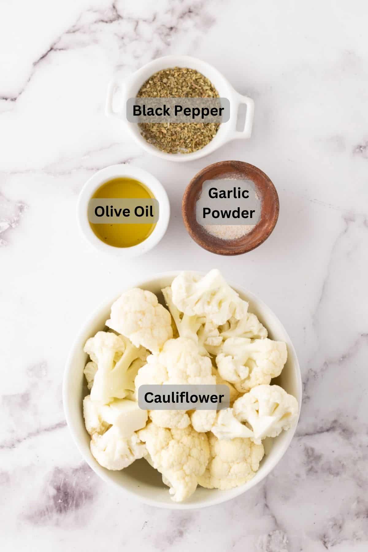 Labeled ingredients with portion bowls each with raw ingredient to make baked cauliflower.