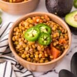 bowl of lentil chili with fresh sliced jalapeño on top.