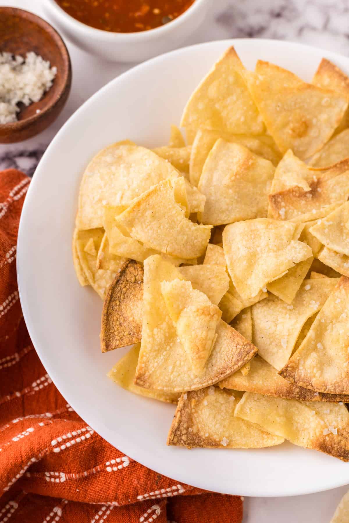 round white plate with homemade baked corn tortilla chips.