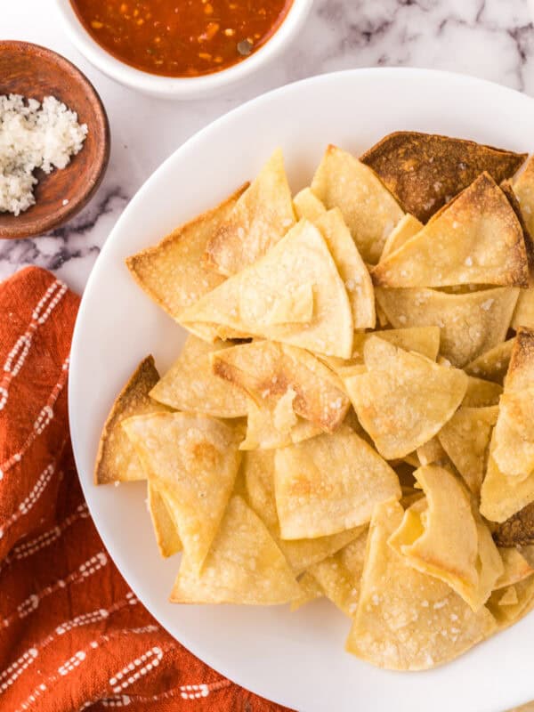 round white plate with homemade baked corn tortilla chips.