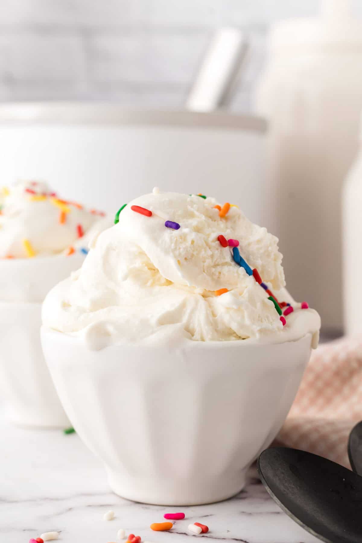 cake batter ice cream in a white dish with rainbow sprinkles.