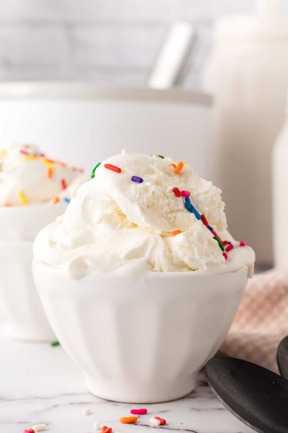 cake batter ice cream in a white dish with rainbow sprinkles.