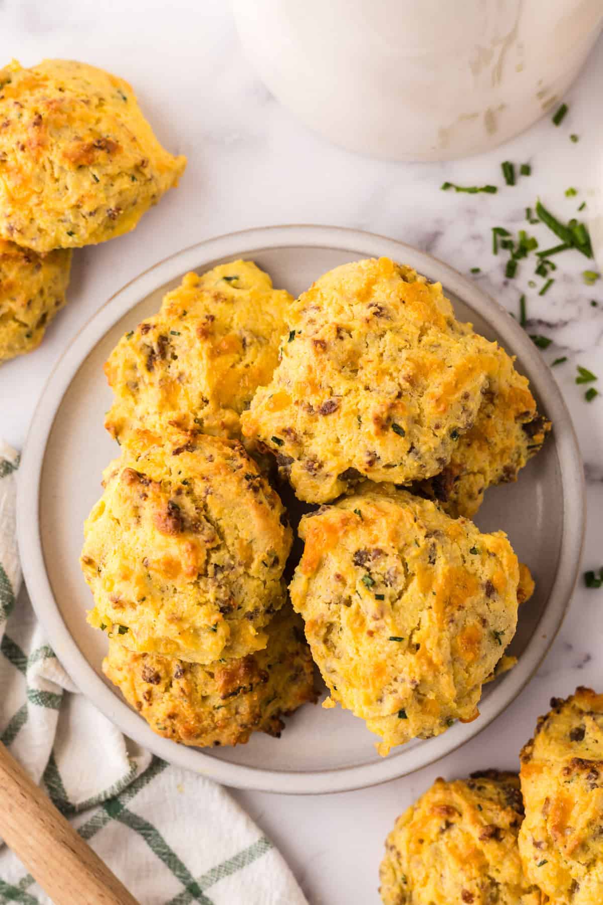 small white bowl with a pile of cheddar sausage biscuits.