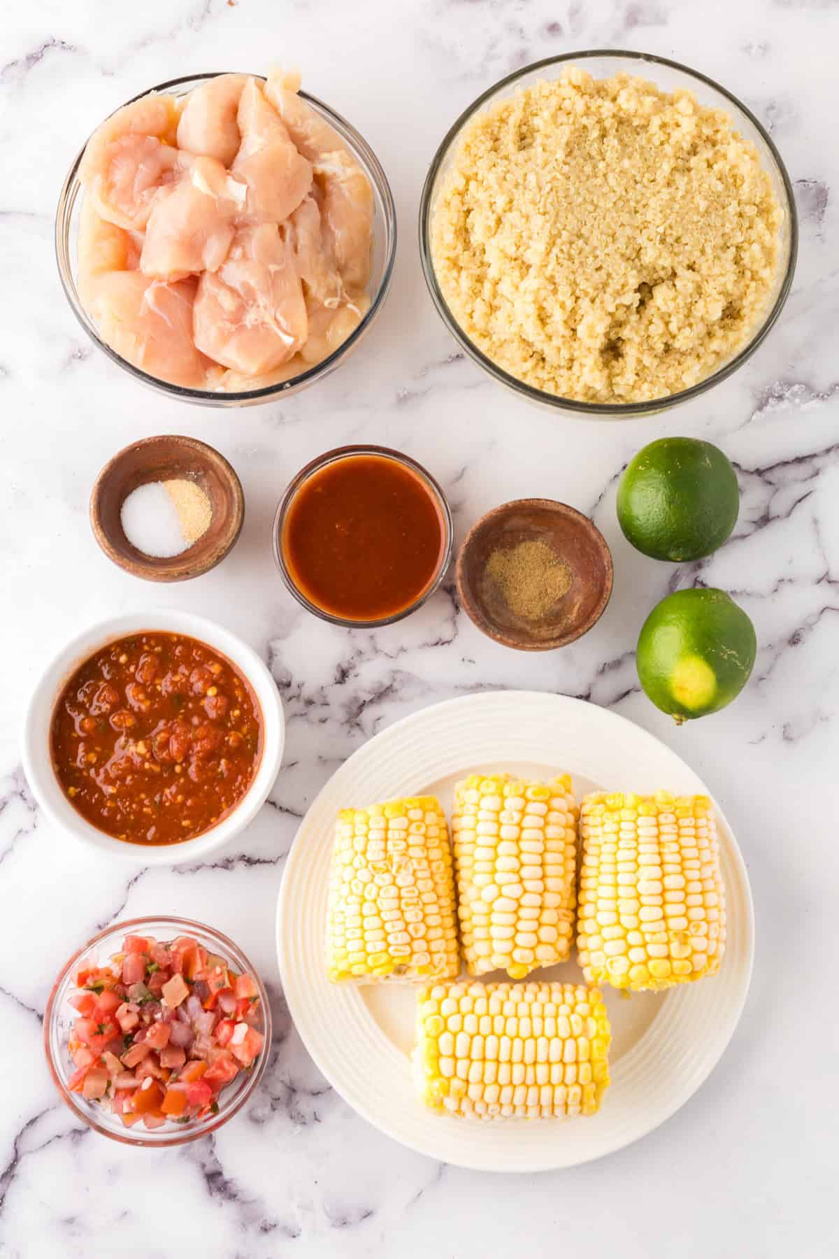 portion bowls each with raw ingredients to make chipotle chicken burrito bowls.