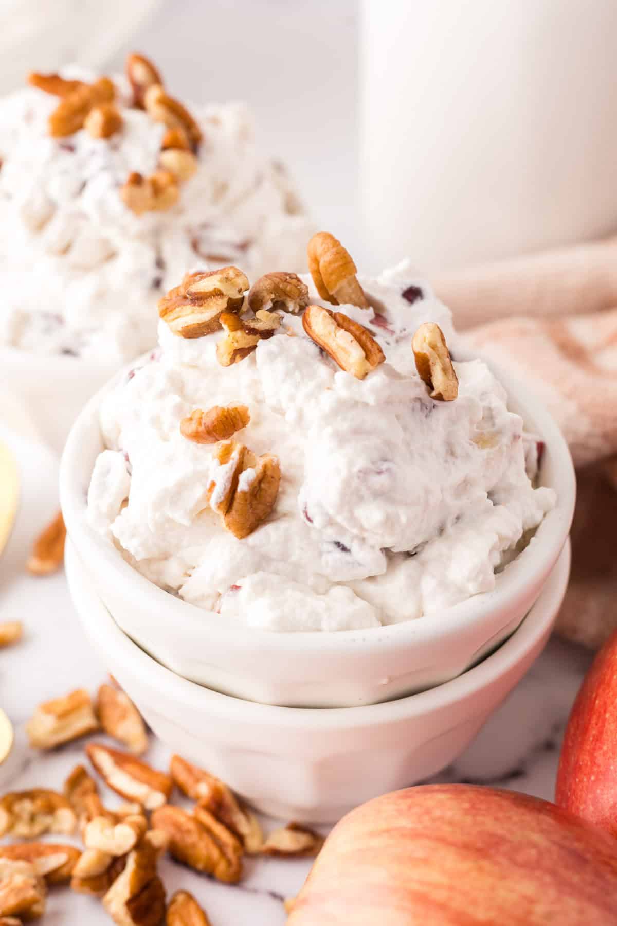 small white portion bowl with dixie salad recipe and walnuts on top.