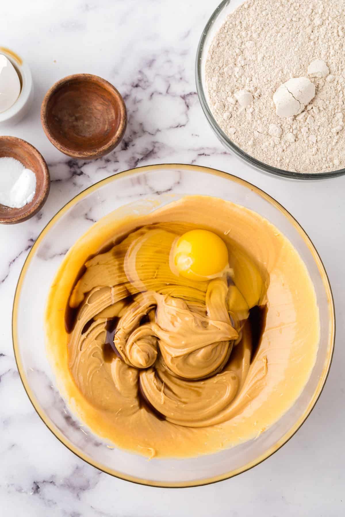 clear mixing bowl the process of making honey peanut butter cookies.