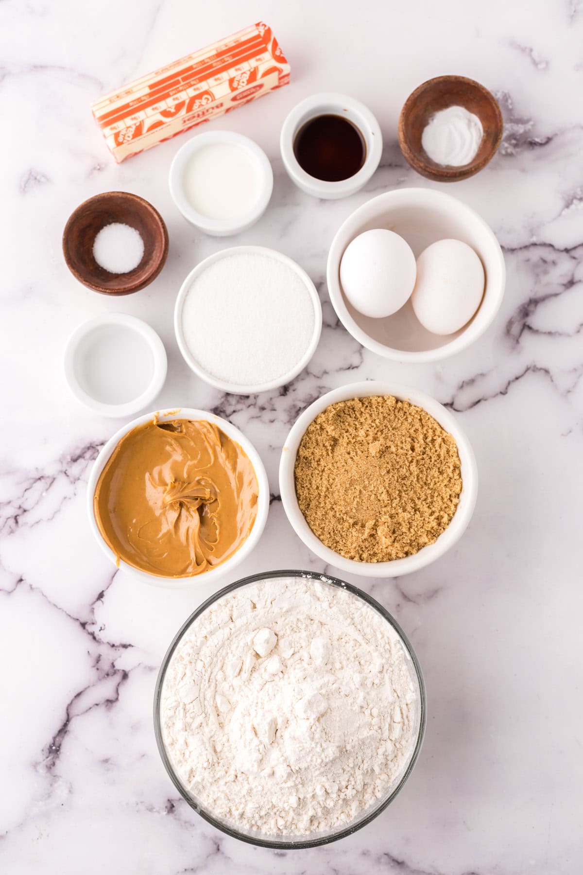 portion bowls each with raw ingredients to make peanut butter cookies.