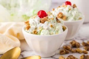 small dish with watergate salad recipe with nuts and a cherry on top.