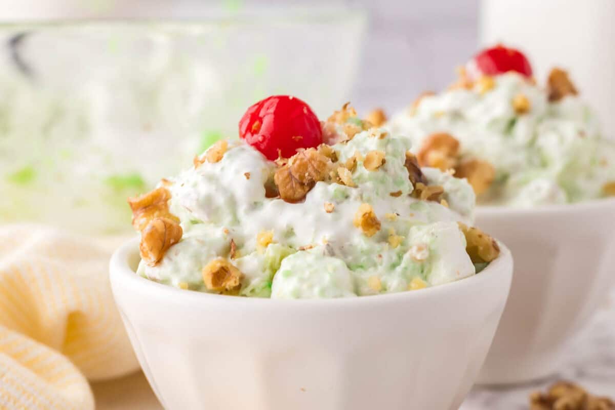 small dish with watergate salad recipe with nuts and a cherry on top.