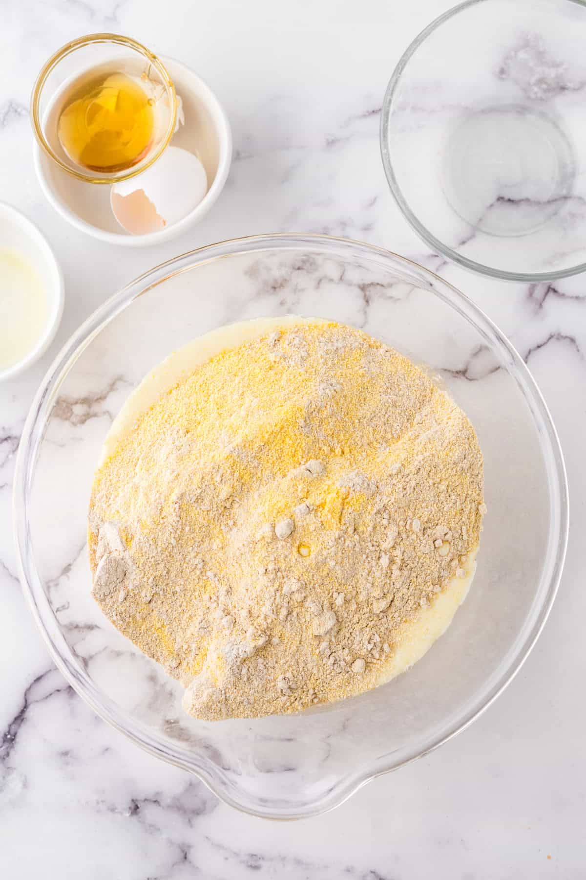 clear mixing bowl in the process of making the whole wheat cornbread recipe.