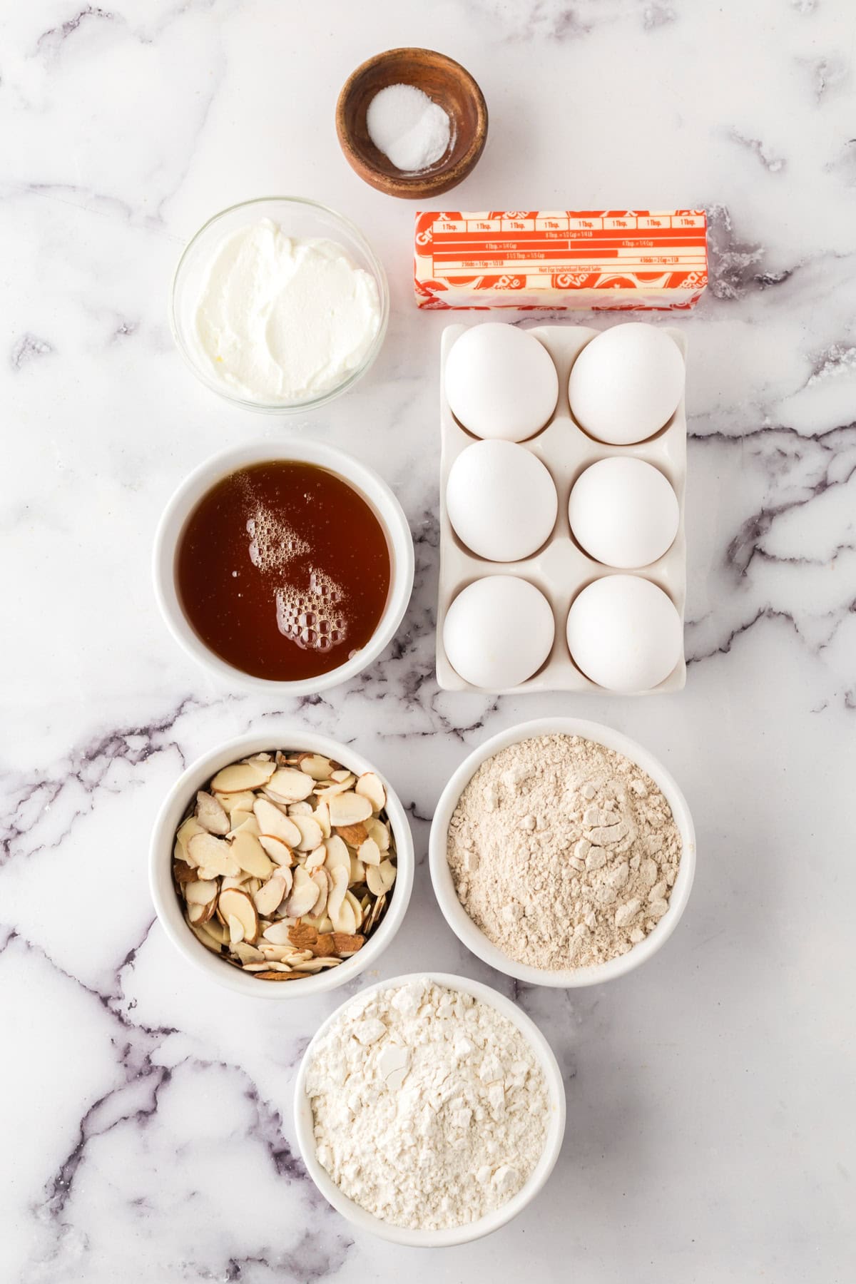 portion bowls each with raw ingredients to make the whole wheat honey cake recipe.