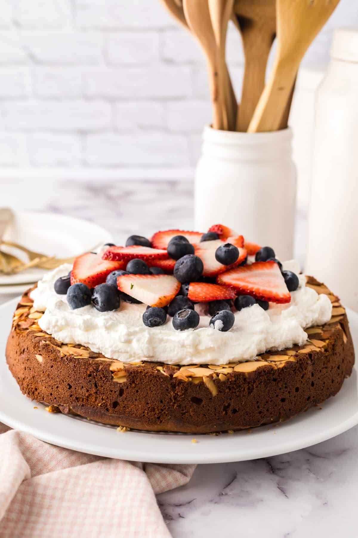 round whole wheat honey cake recipe with whipped topping and berries.