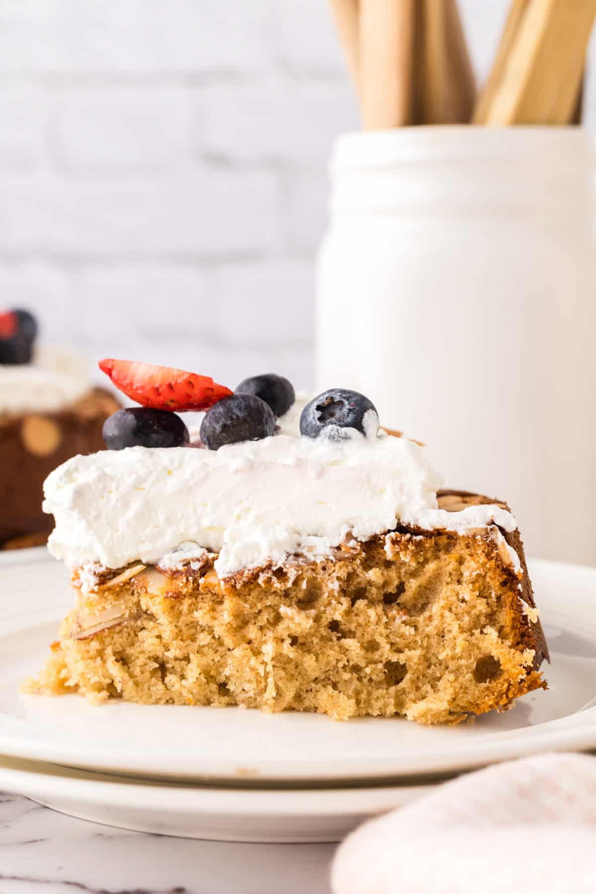 one slice of whole wheat honey cake recipe with whipped topping and berries.
