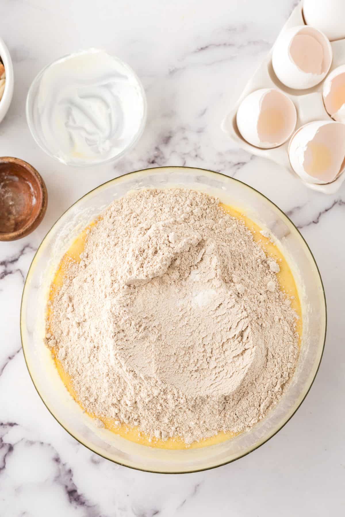 clear mixing bowl in the progress of making whole wheat honey cake.