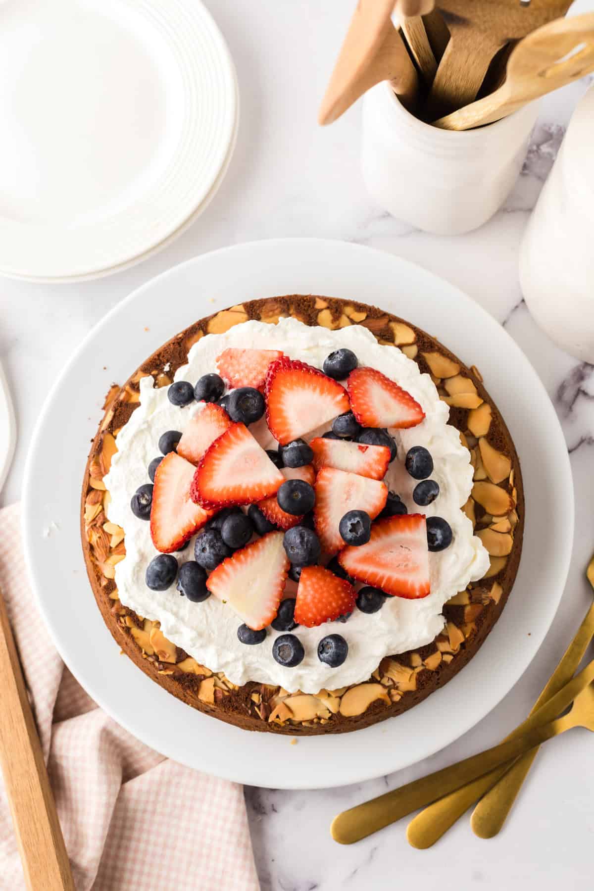 round whole wheat honey cake recipe with whipped topping and berries.